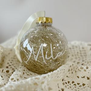 Kerstbal doorzichtig goud met naam witte letters.jpeg